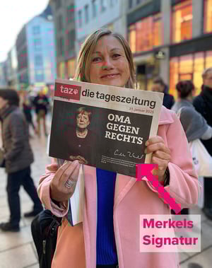 Silke Burmester mit der taz, auf deren Titelbild das Altkanzlerin Angela Merkel die Aktion "Oma gegen Rechts" signiert hatte. 